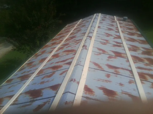 Rusted metal roof panels with new wood purlins before replacement — Storm Damage Roof Repair in Sharon by Roofing Brothers