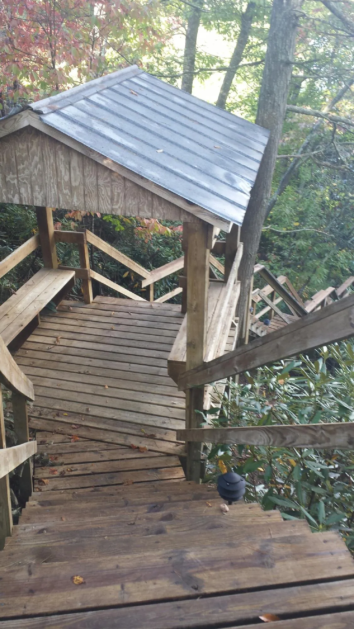 Metal roofed shelter over wooden steps on a wooded walkway — Skylight Repair & Installation work by our crew in Sharon